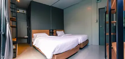 a bedroom with two beds and a green wall at Bed garden 26 in Bangkok