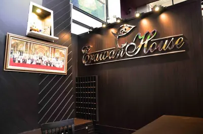 a sign on the wall of a restaurant at Erawan House in Bangkok