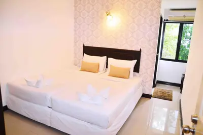 a bedroom with a large white bed with two pillows at Erawan House in Bangkok
