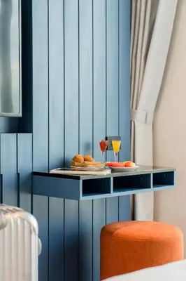 a blue wall with a table with food and drinks at Hotel Amber Sukhumvit 85 in Bangkok