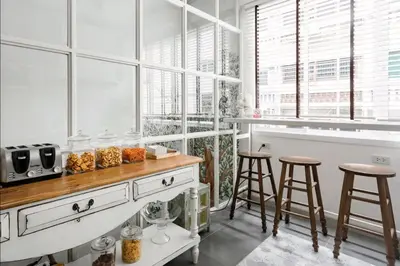 a kitchen with a counter with stools and windows at Hide and Seek Boutique Hometel in Bangkok