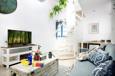 a living room with a couch and a tv at Hide and Seek Boutique Hometel in Bangkok
