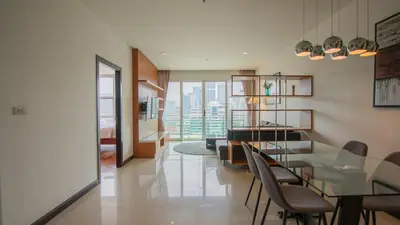 a dining room and living room with a view of the city at Prime 11, High Floor Over Pool, 2 Br, 2 Balcony in Bangkok