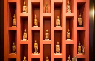a display of statues on shelves in a museum at Baan Wanglang Riverside, Bangkok in Bangkok