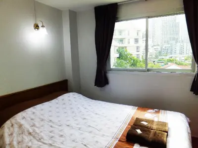 a bedroom with a bed and a window at Orchid Inn in Bangkok