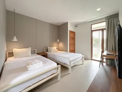 a bedroom with two beds and a window at SUNKISS in Bangkok Noi