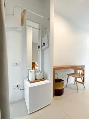 a white bathroom with a table and a mirror at SUNKISS in Bangkok Noi