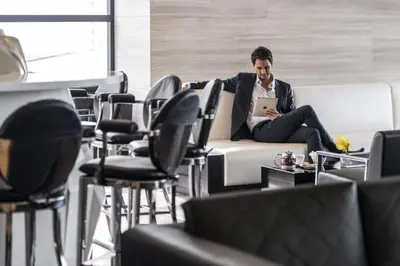 a man sitting on a couch with a laptop at Holiday Inn Bangkok Sukhumvit by IHG in Bangkok