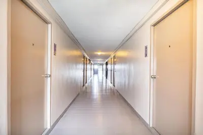 a corridor of a hospital hallway with white tile floors and ceilings at Livotel Express Hotel Ramkhamhaeng 50 Bangkok - No Parking in Bangkok