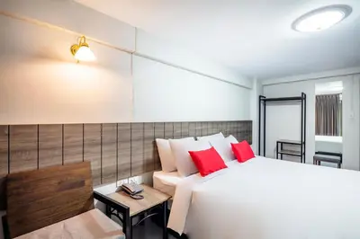a bedroom with a white bed and red pillows at Livotel Express Hotel Ramkhamhaeng 50 Bangkok - No Parking in Bangkok