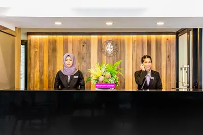 two women are standing in front of a desk at Livotel Express Hotel Ramkhamhaeng 50 Bangkok - No Parking in Bangkok