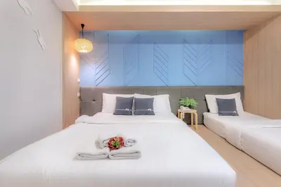 a bedroom with two beds with flowers on the bed at Tori Prestige Bangkok Hotel in Bangkok