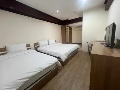 a hotel room with two beds and a flat screen tv at Komol Residence Bangkok in Bangkok