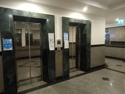 a lobby with two elevators in a building at Komol Residence Bangkok in Bangkok