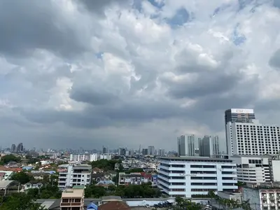 a city skyline with buildings and a cloudy sky at Komol Residence Bangkok in Bangkok