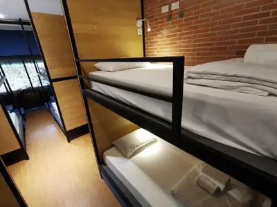 a room with two bunk beds and a brick wall at A Bangkok Journey in Bangkok
