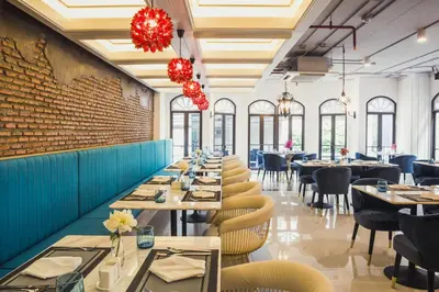 a dining room with tables and chairs and a brick wall at Daraya Boutique Hotel in Bangkok