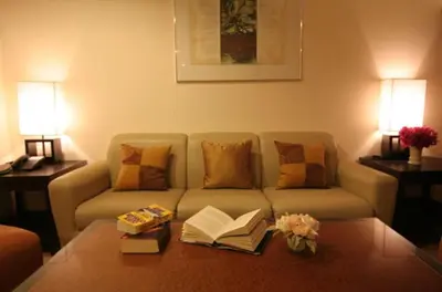 a living room with a couch with books on a coffee table at Rose Hotel in Bangkok