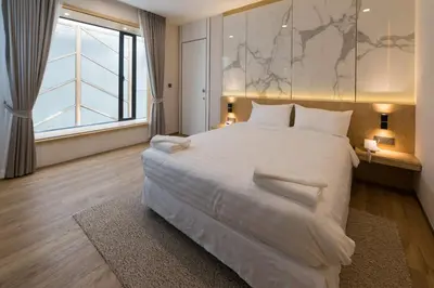 a large white bed in a room with a large window at Artino Hotel Silom in Bangkok