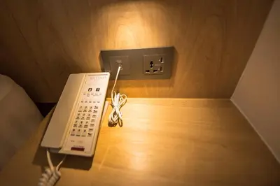 a telephone sitting on top of a wooden table at Artino Hotel Silom in Bangkok
