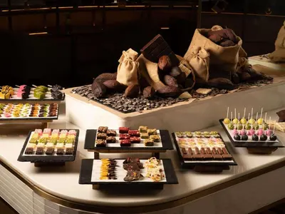 a display case with many different types of desserts at Mövenpick BDMS Wellness Resort Bangkok in Bangkok