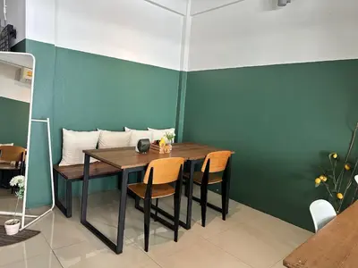 a dining room with a wooden table and chairs at Pingplalee Female House in Bangkok