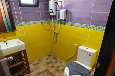 a bathroom with a toilet and a sink at Lilliput Riverside Bangkachao in Samutprakarn