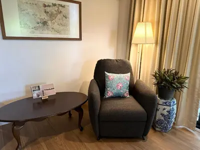a living room with a chair and a table at Cozycomo Bangkok in Bangkok