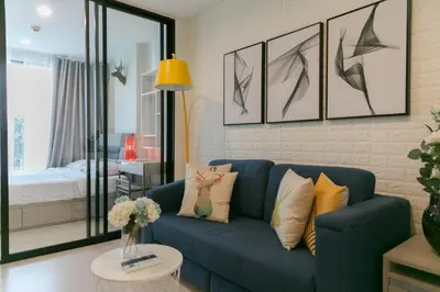 a living room with a blue couch and a bedroom at Moonlight Goddess in Bangkok
