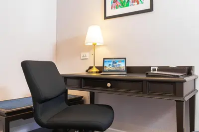 a desk with a chair and a laptop on it at Le Siam Hotel Silom Bangkok by PCL in Bangkok
