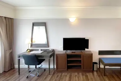 a hotel room with a desk and a television at Le Siam Hotel Silom Bangkok by PCL in Bangkok