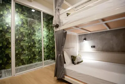 a bedroom with a bed and a large window at Siam Eco Hostel in Bangkok