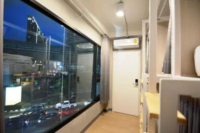 a room with a view of a city through a window at Siam Eco Hostel in Bangkok