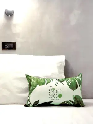 a pillow sitting on top of a white bed at Siam Eco Hostel in Bangkok