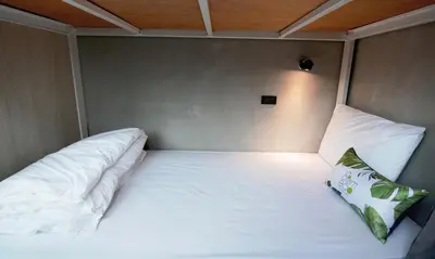 a white bed with two pillows in a room at Siam Eco Hostel in Bangkok