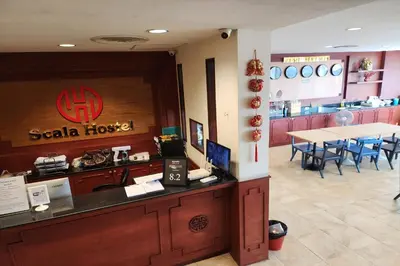 a restaurant with a counter and a table with chairs at Scala Hostel in Bangkok