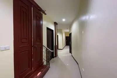 a hallway with a wooden door and a hallway with at Scala Hostel in Bangkok