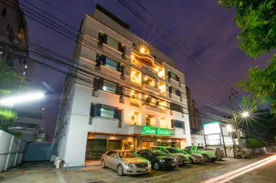 a building with cars parked in front of it at Siam Palace Hotel in Bangkok