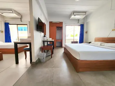 a bedroom with a bed and a desk in it at Siam Palace Hotel in Bangkok