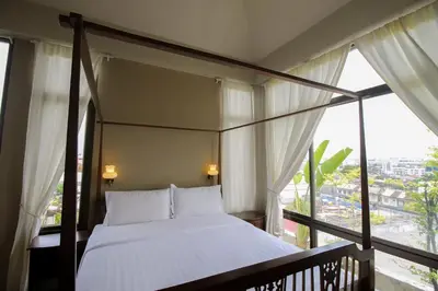 a bedroom with a canopy bed and a large window at Sourire at Rattanakosin Island Hotel in Bangkok