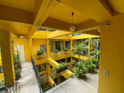 an empty yellow building with plants on the balconies at Sourire at Rattanakosin Island Hotel in Bangkok