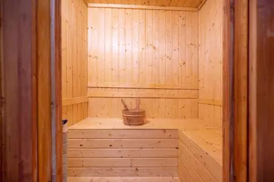 a wooden sauna with a bench and a bucket in it at Kokotel Bangkok Dheva Thonglor in Bangkok