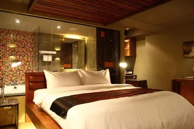a bedroom with a large bed and a bathroom at The Fusion Suites in Bangkok