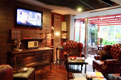 a living room with couches and a television on a wall at The Fusion Suites in Bangkok
