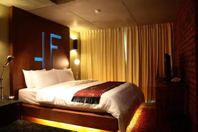 a bedroom with a bed and a television in it at The Fusion Suites in Bangkok
