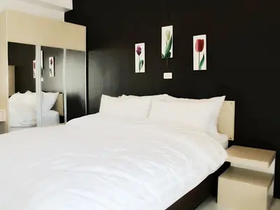 a bedroom with a white bed and some pictures on the wall at J.K. Mansion in Bangkok