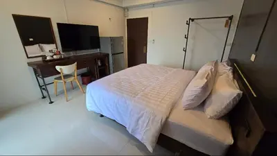 a bedroom with a bed and a desk with a computer at J.K. Mansion in Bangkok