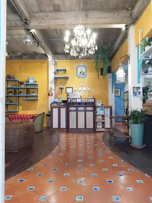 a room with yellow walls and a chandelier at Time Sabai 32 in Bangkok