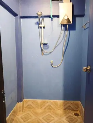 a shower in a bathroom with a blue wall at Time Sabai 32 in Bangkok