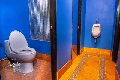 a bathroom with a toilet and a urinal at Time Sabai 32 in Bangkok